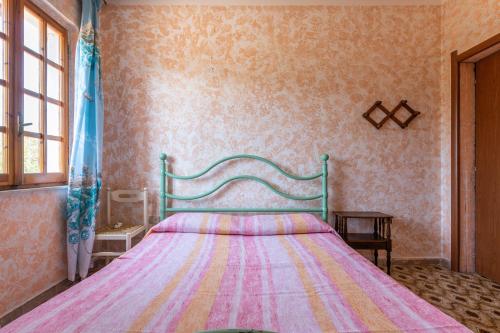 a bedroom with a bed with a colorful blanket at Casa vacanza Elena in Sarroch