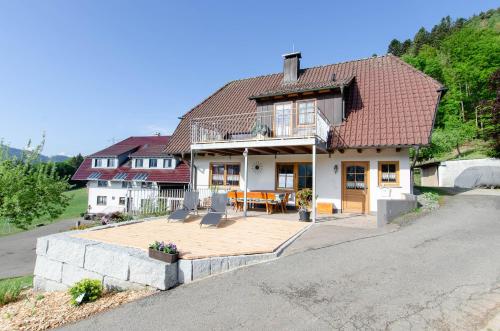 a house with a wooden deck in the driveway at Vordersbergerhof in Hausach