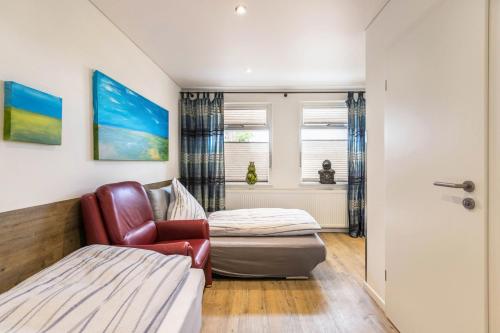 a room with a bed and a chair and a window at Treibholz - Feriendomizil Ostsee in Schönberger Strand
