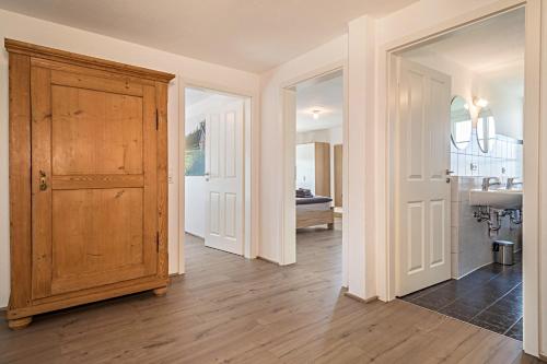 a hallway with a wooden door and a kitchen at Ferienwohnung am Hopfengarten in Tettnang