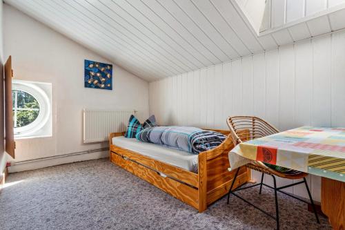 a small bedroom with a bed and a table at Kranichblick in Lüdershagen