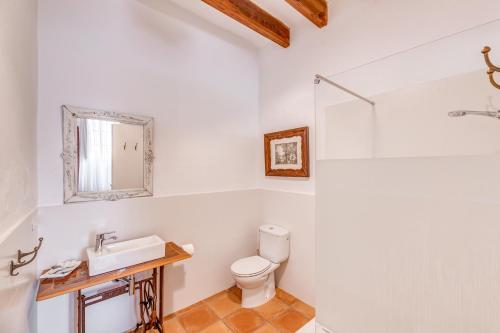 a bathroom with a toilet and a sink and a mirror at Finca Buniferri in Llucmajor