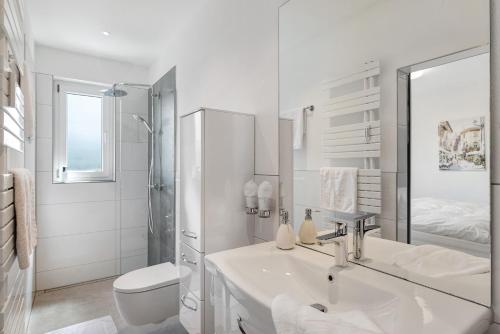 a white bathroom with a sink and a toilet at Modern eingerichtetes Apartment in Achern