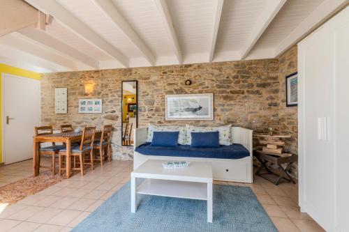 a bedroom with a bed and a table in a room at La Maison du Gardien in Portsall