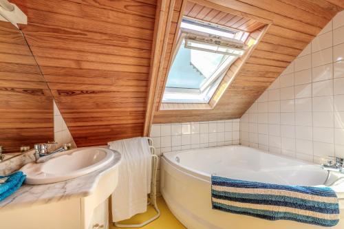 a bathroom with a tub and a sink at La Maison du Gardien in Portsall