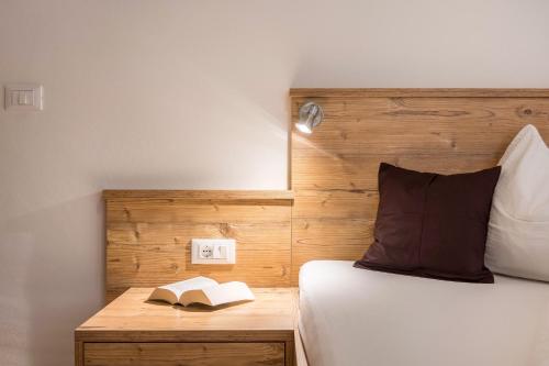 a bedroom with a bed and a book on a table at App Ringelblume Biohof Unterspisser in Laion