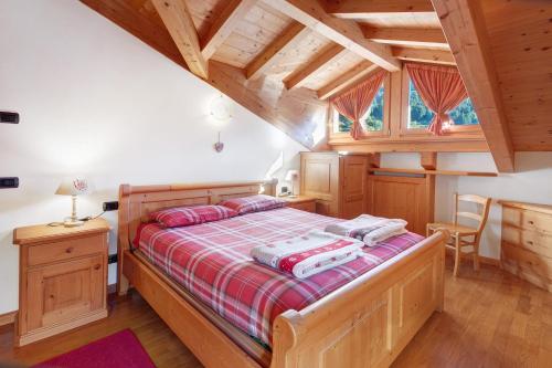 a bedroom with a bed with a red and white blanket at Mansarda Combo in Bormio