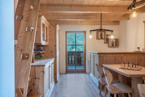 a kitchen with wooden walls and a large island with chairs at App Ringelblume Biohof Unterspisser in Laion