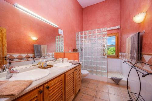 a bathroom with two sinks and a toilet and a shower at Finca Can Xerpeta in Son Servera