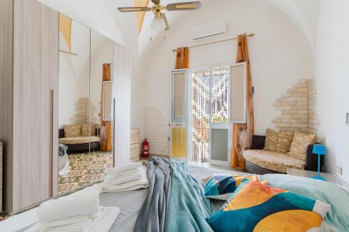 a living room with a bed and a couch at Kyma monolocale ad Otranto in Otranto