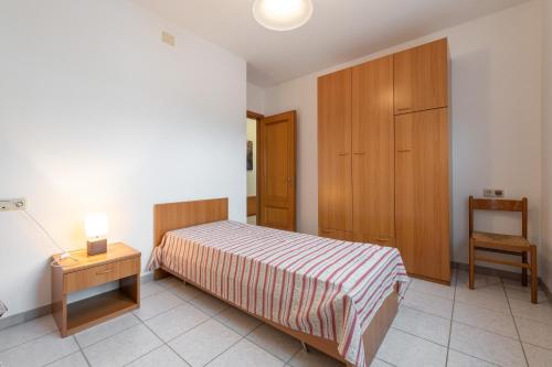 a small bedroom with a bed and a night stand at Casa Colonia 2 in SantʼAnna Arresi