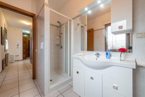 a white bathroom with a sink and a shower at Casa Colonia 2 in SantʼAnna Arresi