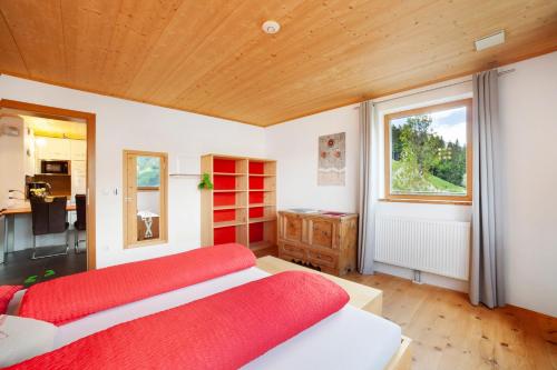 a bedroom with two red beds and a window at Joshof Talblick in Moso