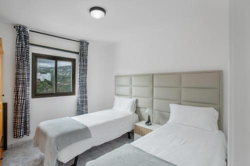 a bedroom with two beds and a window at El Granero in Moya