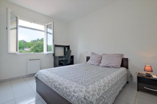 a white bedroom with a bed and a window at Le Perchoir Avec Piscine et Clim in Savignac-les-Églises