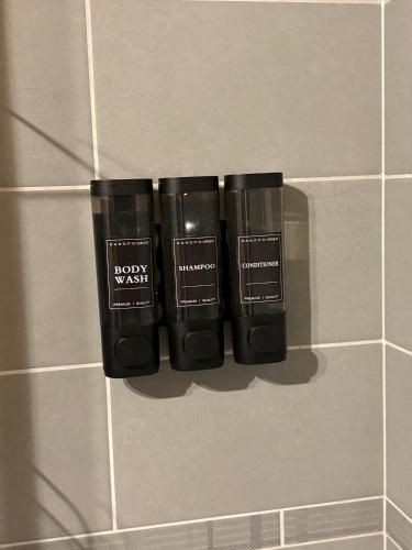 a group of three black bottles on a tiled wall at Chalet Clemalou 14-15 Personnes in Châtel