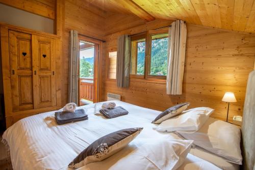 a bedroom with a bed in a log cabin at Chalet Clemalou 14-15 Personnes in Châtel