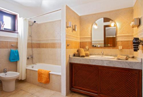 a bathroom with a sink and a tub and a toilet at Villa Haere Mai in La Asomada