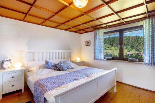 a bedroom with a bed and a large window at Ferien auf der Fleischdielte in Mühlenbach