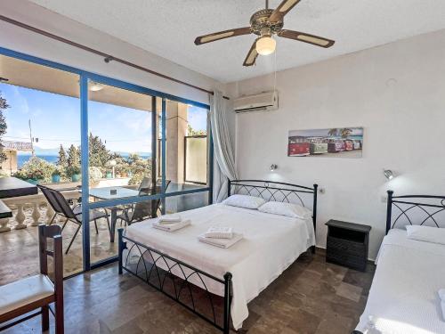 a bedroom with a bed and a balcony with a table at Andromaches large apartment 2 in Corfu