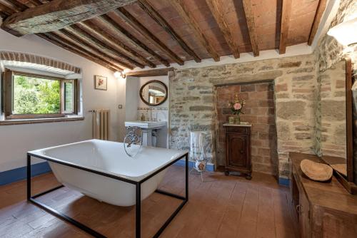 a bath tub in a room with a stone wall at La Casa di Colle in Dicomano