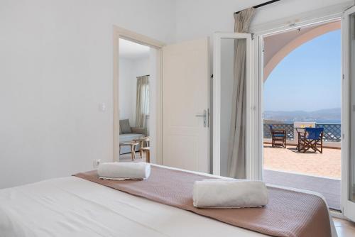 a bedroom with a bed and a view of the ocean at Lefkanthemo Apartment in Astypalaia