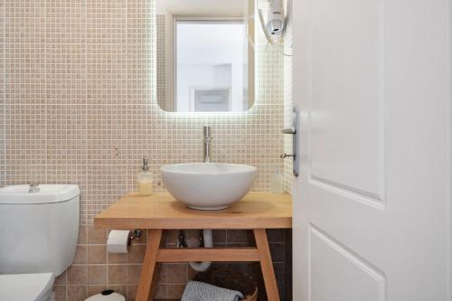 a bathroom with a white bowl sink and a mirror at Lefkanthemo Apartment in Astypalaia
