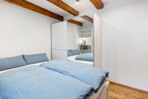 a bedroom with a bed and a white wall at Ferienwohnung Haas in Bräunlingen