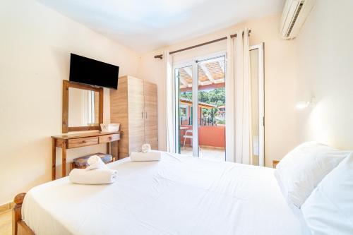 a bedroom with a white bed and a window at Arianna apartment 17 in Paleokastritsa