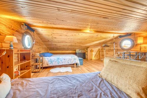 a bedroom with two beds in a wooden cabin at Maison Les Pieds Dans L'eau in Le Verdon-sur-Mer