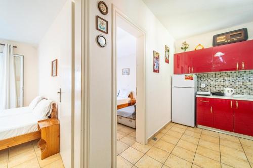 a kitchen with red cabinets and a white refrigerator at Arianna apartment 17 in Paleokastritsa