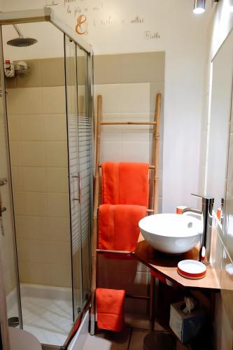 a bathroom with an orange chair and a sink at La Petite Maison De Noémie in Gras