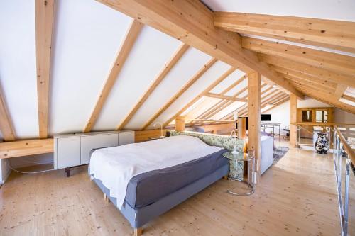 a bedroom with a bed in a room with wooden ceilings at Maisonettewohnung am Wössener See in Unterwössen