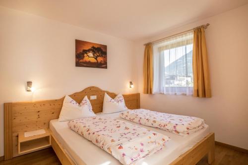 a bedroom with a bed and a window at Apartment Alpenrose - Mesnerhof in Campo Tures