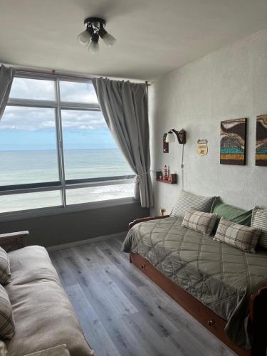 a bedroom with two beds and a large window at Playa Club in Miramar