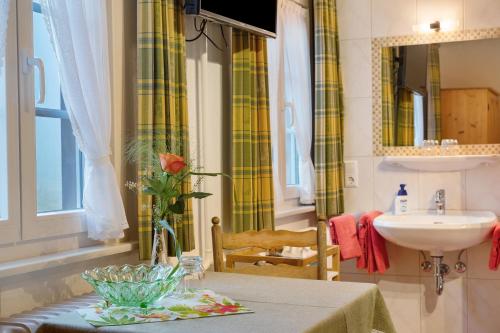 a bathroom with a sink and a table with a vase at Haus Luise in Lenzkirch in Lenzkirch