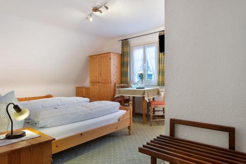 a bedroom with a bed and a table and a chair at Haus Luise in Lenzkirch in Lenzkirch