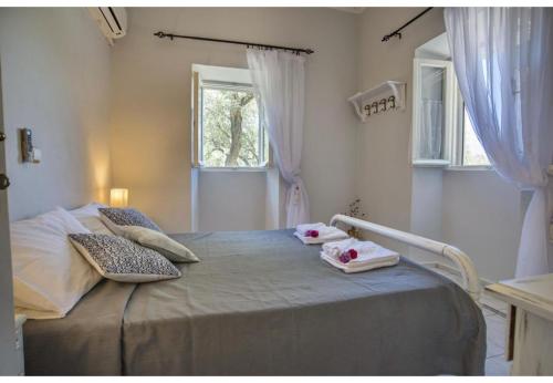 ein Schlafzimmer mit einem Bett, auf dem zwei Handtücher liegen in der Unterkunft Villa Dendro in Lákka
