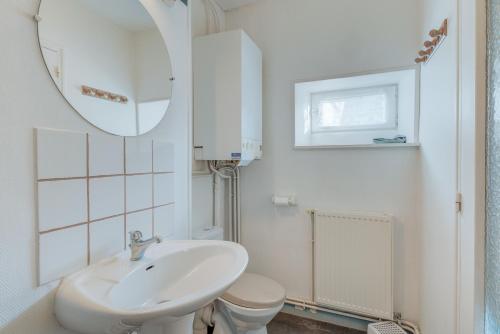 a white bathroom with a sink and a toilet at Maison proche Mont St Michel in Pontorson