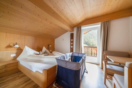 a bedroom with a bed and a desk and a window at Sonnleiten der kleinen Bären 8 in Collepietra