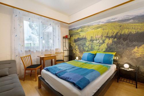 ein Schlafzimmer mit einem Bett und einem Gemälde an der Wand in der Unterkunft Ferienwohnung Gartenblick in Freiamt