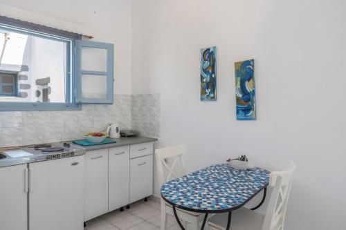 a small white kitchen with a table and a table and a table and a table at Pico Bello Patmos 18 in Patmos