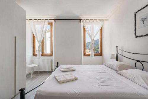 a white bedroom with a bed with two towels on it at La ca bela in Portovenere