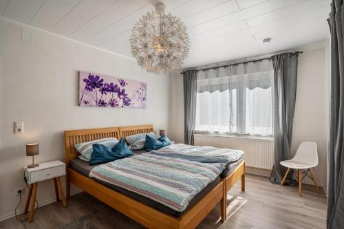 a bedroom with a bed and a chandelier at Ferienwohnung Drachenstein in Weinheim