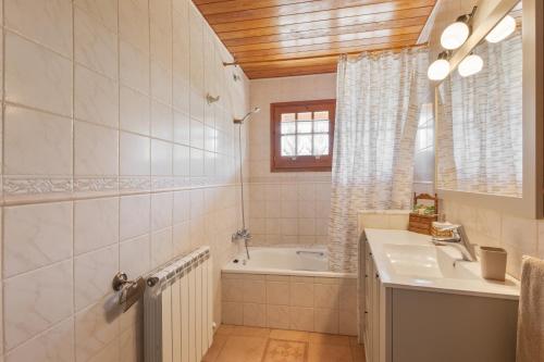 a bathroom with a tub and a sink and a bath tubermottermott at Hospitalillo in Sant Corneli de Cercs 
