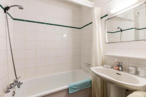 a white bathroom with a tub and a sink at Studio Cosy face à l'océan in Lacanau