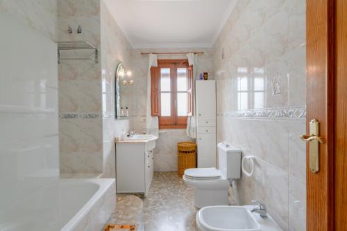 a bathroom with a toilet and a tub and a sink at Villa Padial in Torrox