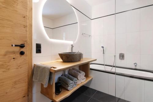 a bathroom with a sink and a mirror at Bertollhof Weingenuss in Silandro