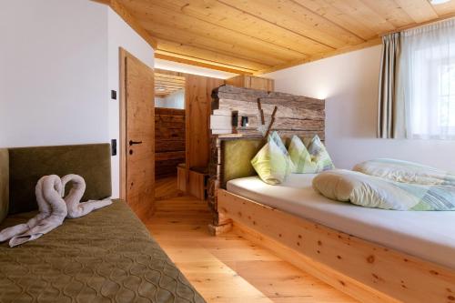 a bedroom with a bed with a wooden headboard at Bertollhof Weingenuss in Silandro