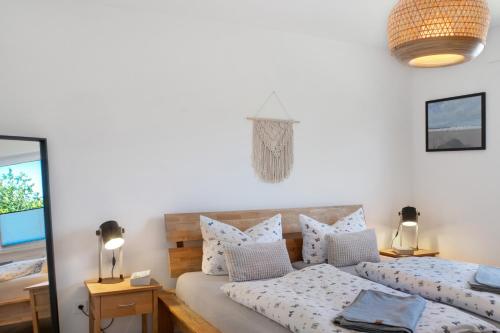 a bedroom with a bed with pillows and a mirror at Deichblick - in 5 min am Meer in Wangerland